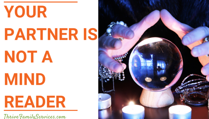 Orange text over a white background that reads "Your Partner is NOT a Mind Reader" to the left of a photo of a close up crystal ball with a white person's hands hovering over it. There are tea lights lit in front of the ball and the background is dark. | Couples Therapy in Greenwood Village Colorado