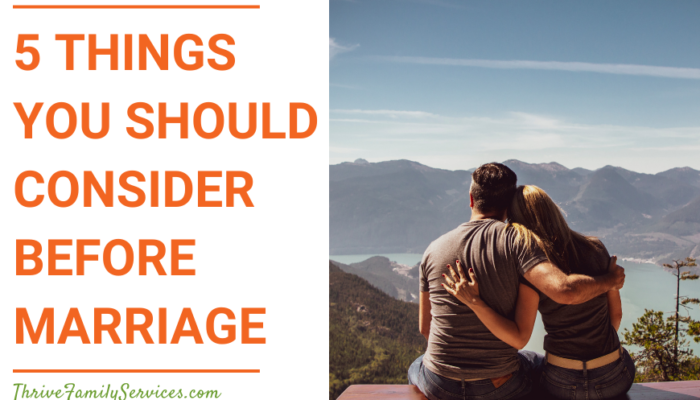 Orange text that reads "5 Things You Should Consider Before Marriage" to the left of a photo of a couple at the summit of a mountain. Their backs are to the camera and they're sitting down with their arms around each other looking at the view of mountains and water. | Englewood Colorado Premarital Counseling