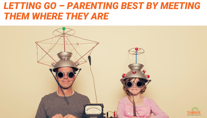 Orange text that reads "Letting Go - Parenting Best by Meeting Them Where They Are" above a photo of a man and a child sitting next to each other wearing zany helmets.