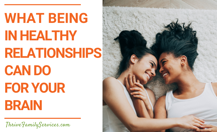 Orange text on a white background that reads "What Being in Healthy Relationships Can Do For Your Brain" to the left of a photo of two women with dark hair embracing on the floor. Their foreheads are touching and they are smiling at one another. | Couples Counseling Englewood Colorado