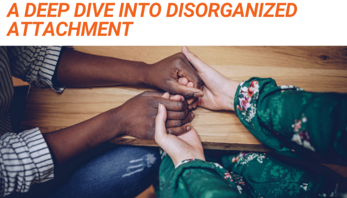 Graphic that reads "A Deep Dive Into Disorganized Attachment" in orange text above a stock photo of a white person and a Black person's hands clasped together on a table.