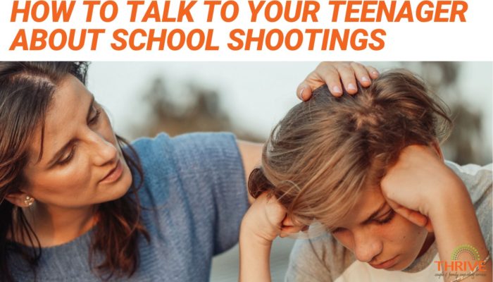 A graphic that reads "How to Talk to Your Teenager About School Shootings" in dark orange text on a white background above a stock photo of a white mother talking to her young teen son, with her hand on his head in comfort. The teen looks upset, with his head in his hands.